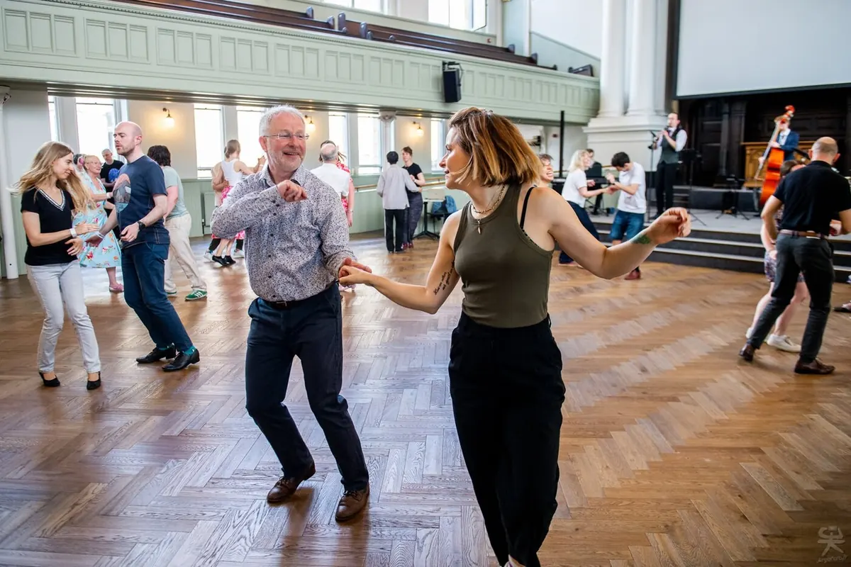 Dancers grinning mid-dance at Glasgow Swing Exchange